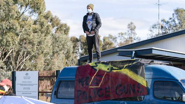 Melbourne group holds 'cease fire' signs at Benalla weapons business